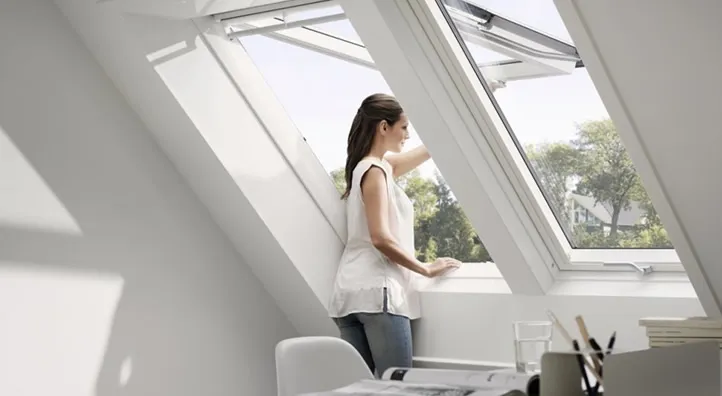 Vrouw opent een Velux dakraam